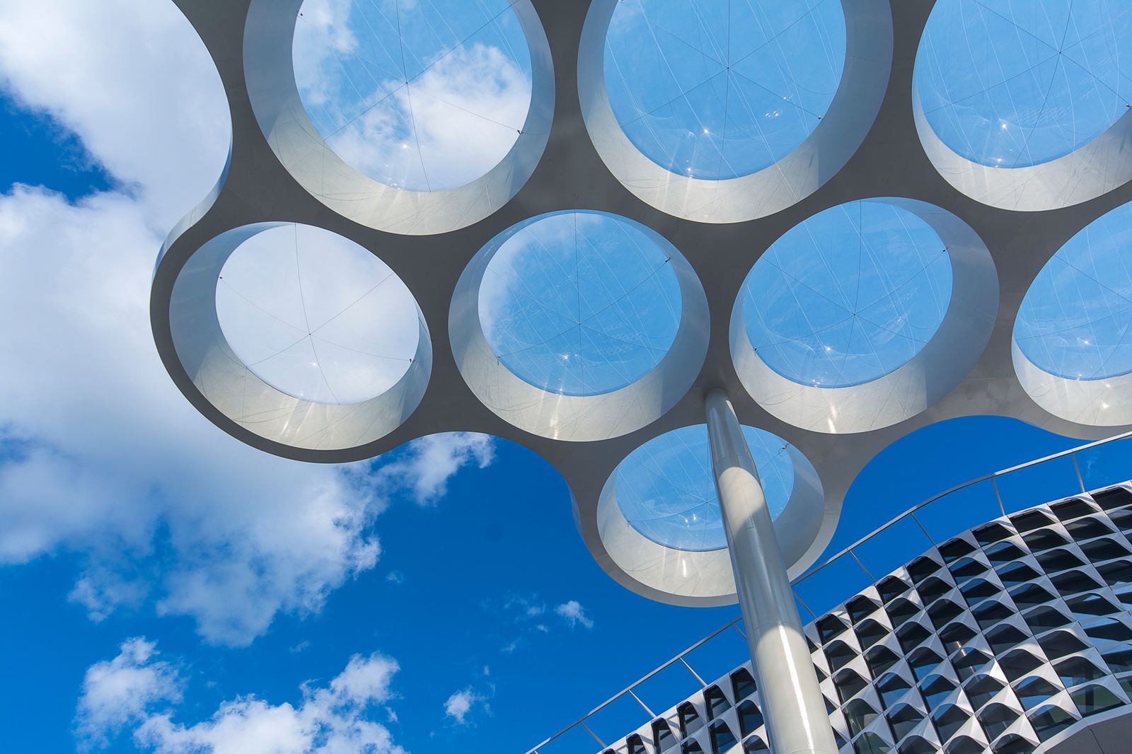 Onderaanzicht van het Bollendak bij Utrecht Centraal, het herkenbare ronde dakontwerp tegen een blauwe lucht