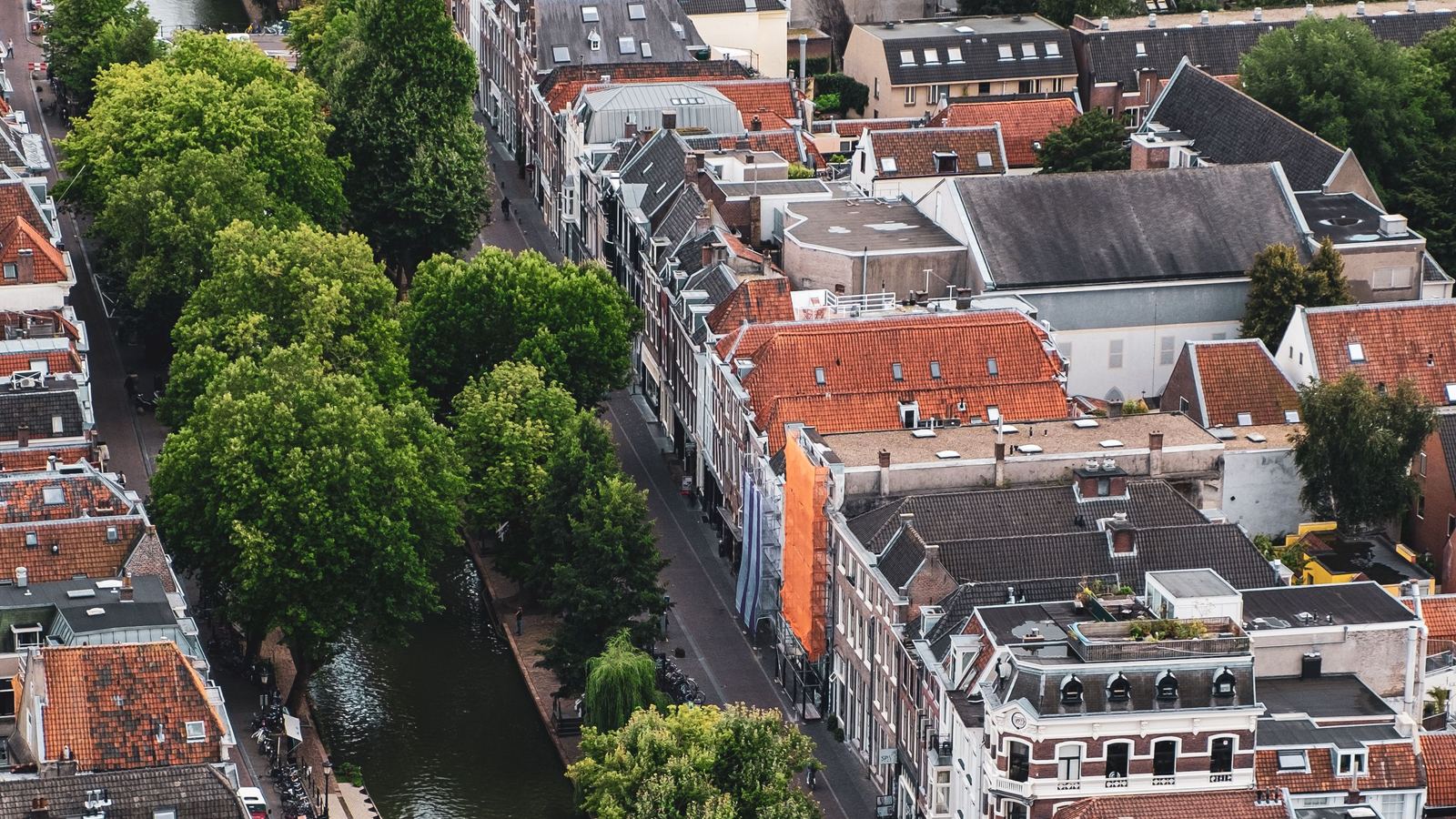 Luchtfoto van een Utrechtse gracht met bomen, fietsen en rijtjeshuizen met rode daken